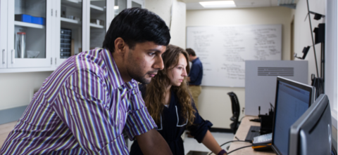 Two students looking at a computer monitor