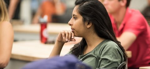 Student with her hand on her chin in a classroom