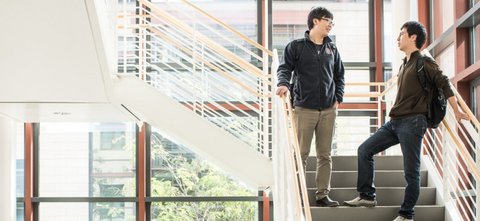 Two students talking on the Packard stairs landing