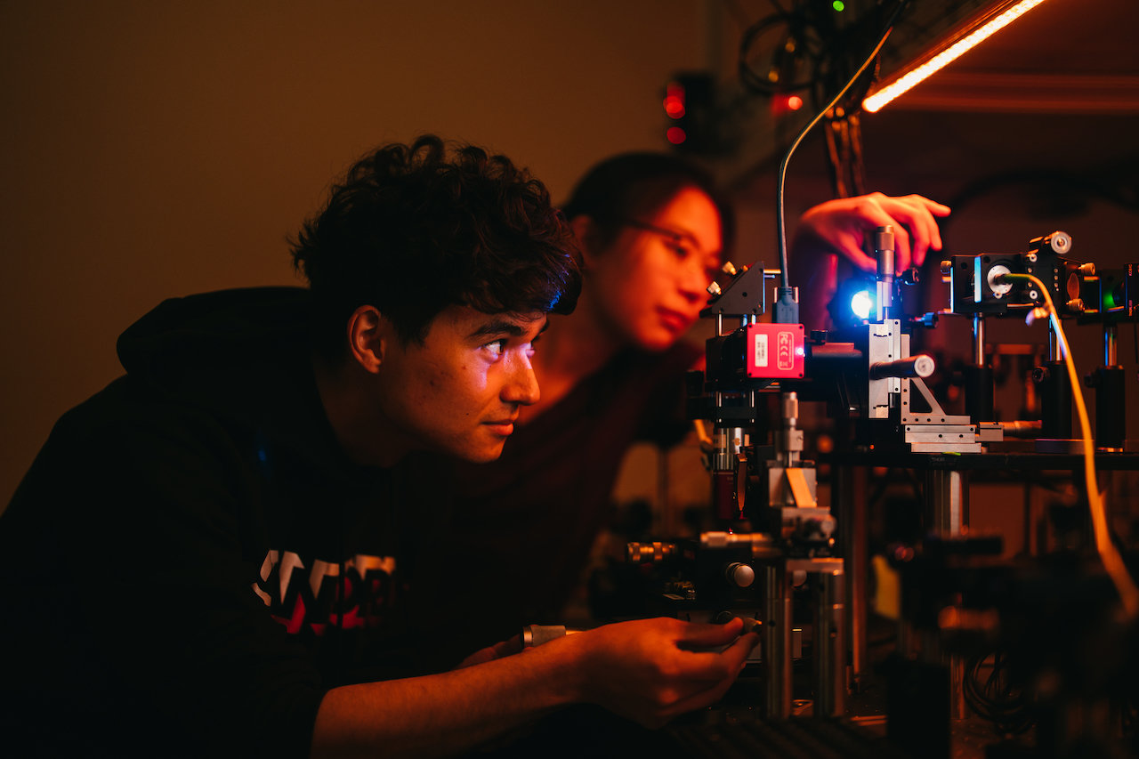 PhD students Hope Lee (right) and Yakub Grzesik (left) align a diamond quantum photonics experiment in Jelena Vuckovic’s Lab